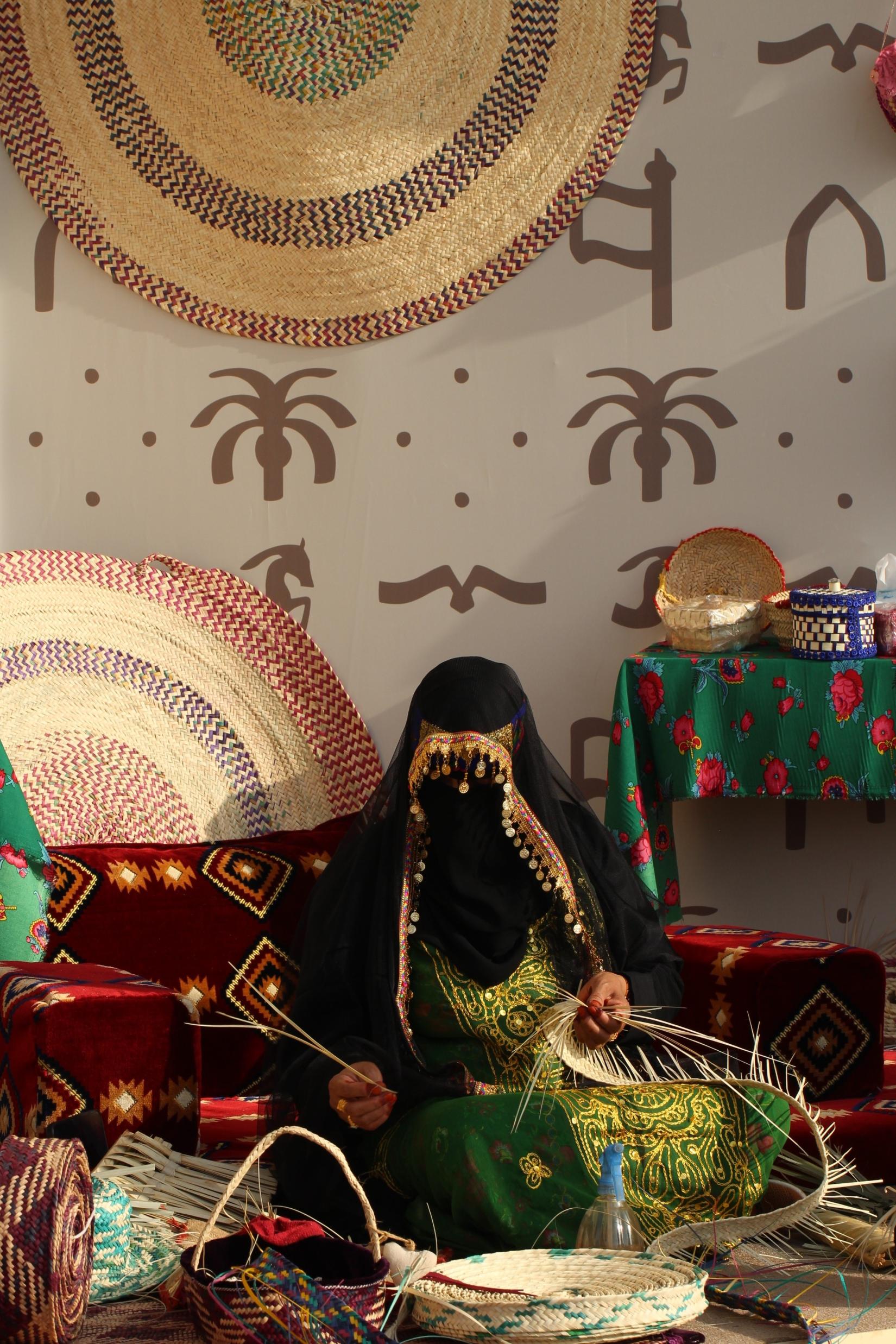 Photo of Woman dressed in traditional clothes working on traditional handcrafts