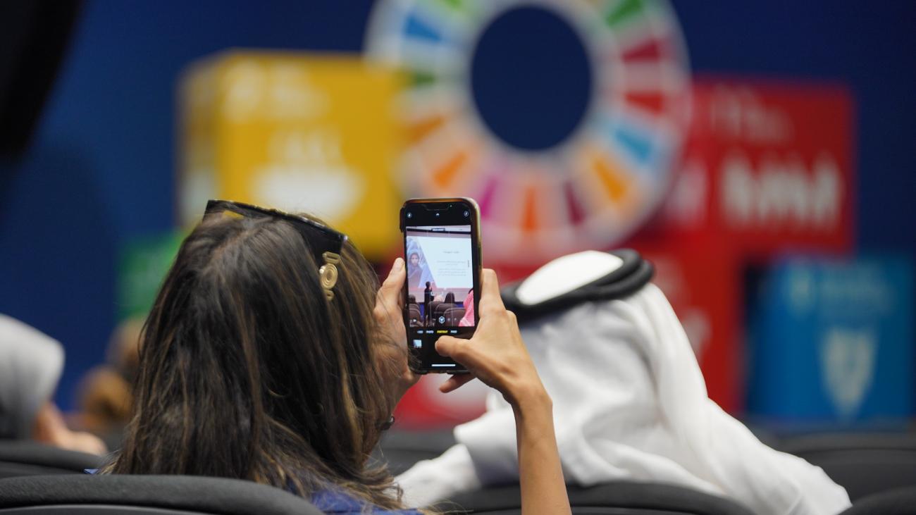 Media Professional capturing a photo with their phone of the UN in Saudi Arabia Media Workshop 2023