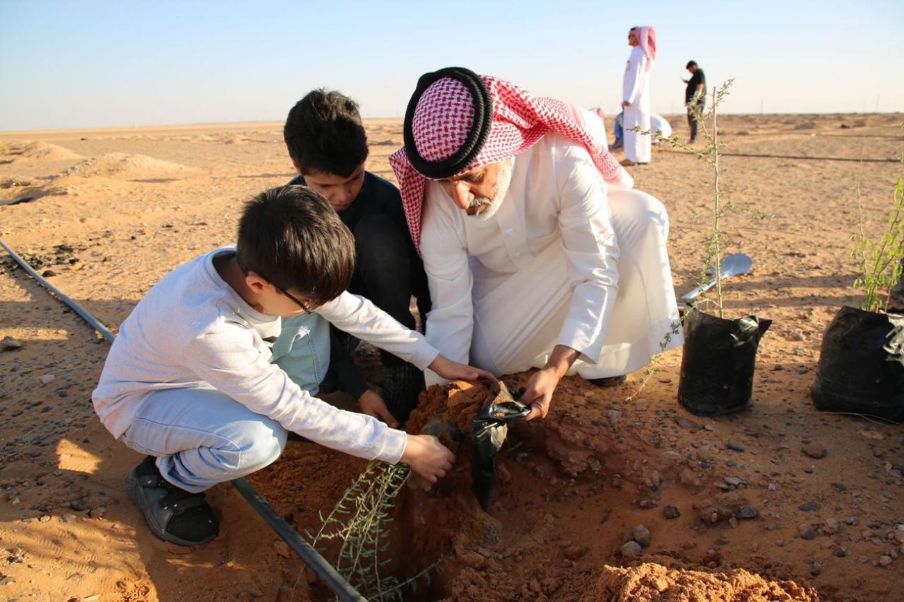 A father planting a tree with his son