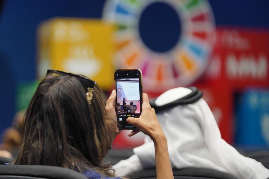 Media Professional capturing a photo with their phone of the UN in Saudi Arabia Media Workshop 2023